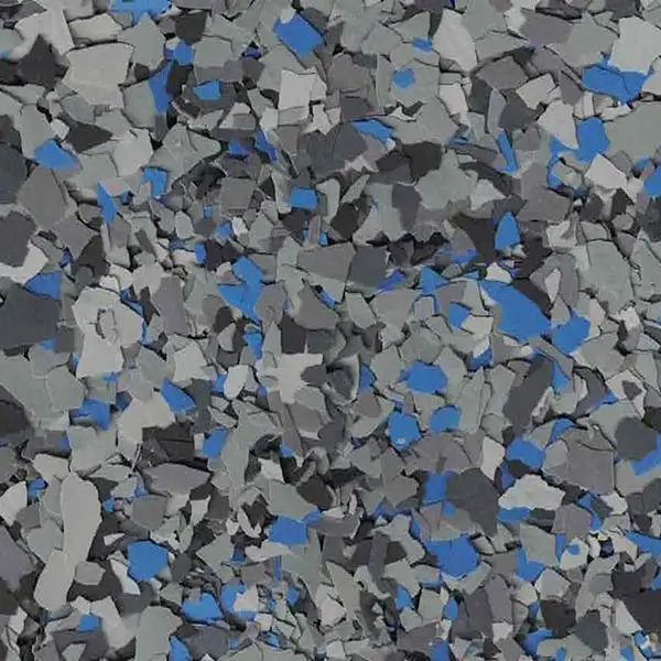 A close-up of textured, multicolored rubber flooring with a mix of gray, blue, and black fragmented shapes, resembling abstract art.