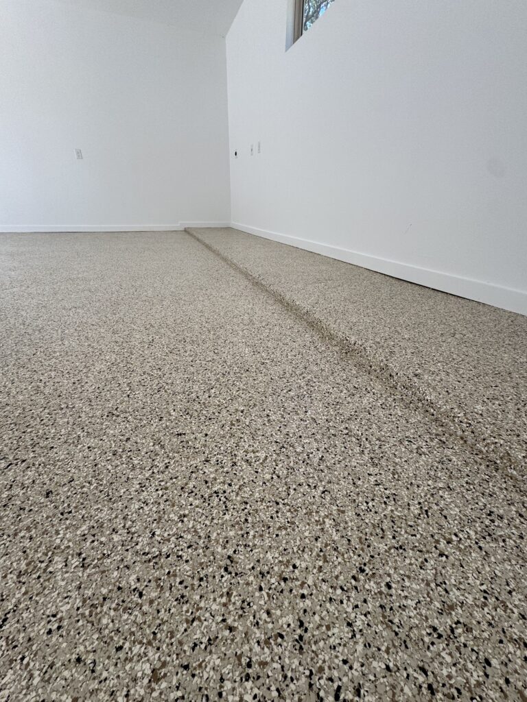 Corner of a bare room with speckled beige carpet, white walls, and baseboards.